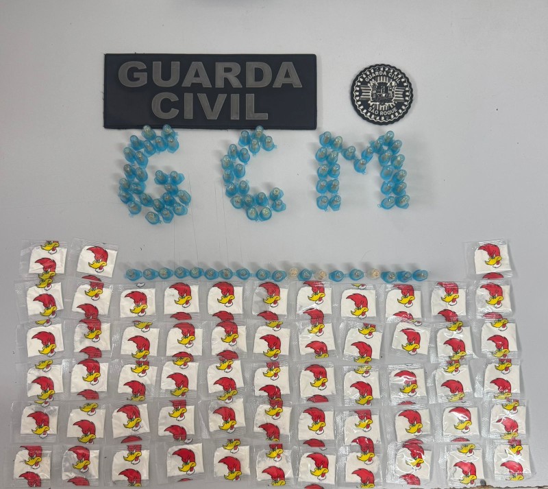 Apreensão de drogas pela Guarda Civil. Na imagem, cápsulas azuis e embalagens com estampa do Pica-Pau, além de distintivos da corporação.