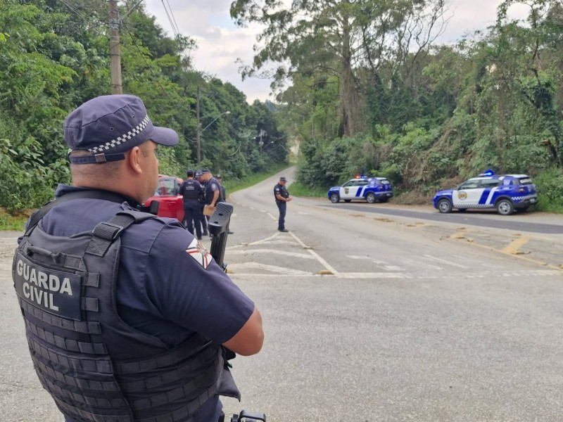 Guardas municipais em ação em rodovia, com viaturas e policiais em patrulhamento. A foto ilustra a intensificação das ações, com viaturas em apoio.