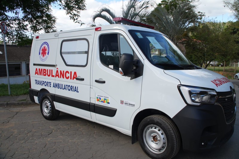 Ambulância do Transporte Ambulatorial de São Roque estacionada. Veículo branco com identificação visual e logotipos.
