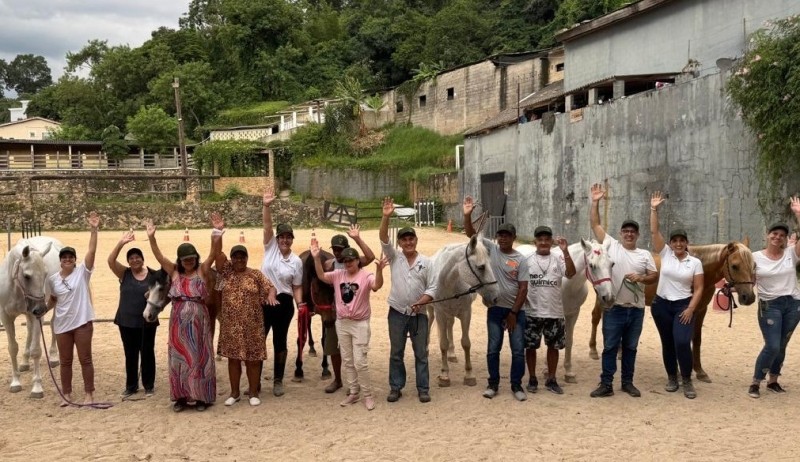 Idosos de São Roque interagem com cavalos no Projeto SARA, promovendo bem-estar e convivência.